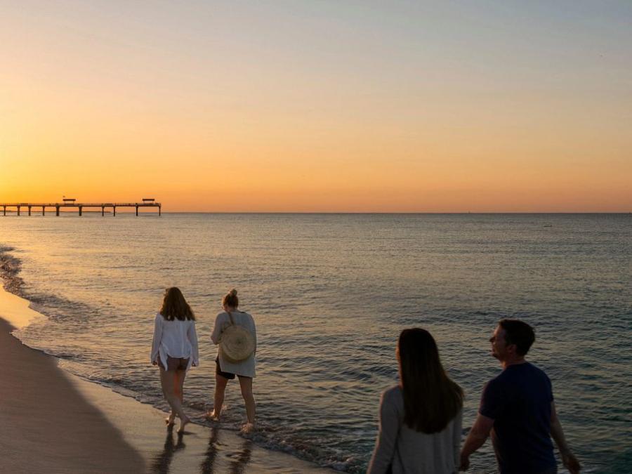 Family walking along the beach at sunrise in Gulf Shores