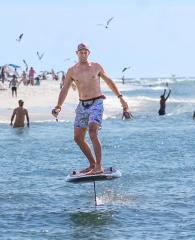 Man riding a foil board near the shore in Orange Beach