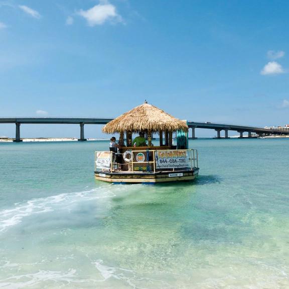 Cruisin' Tikis Orange Beach tiki boat in the clear water of Orange Beach