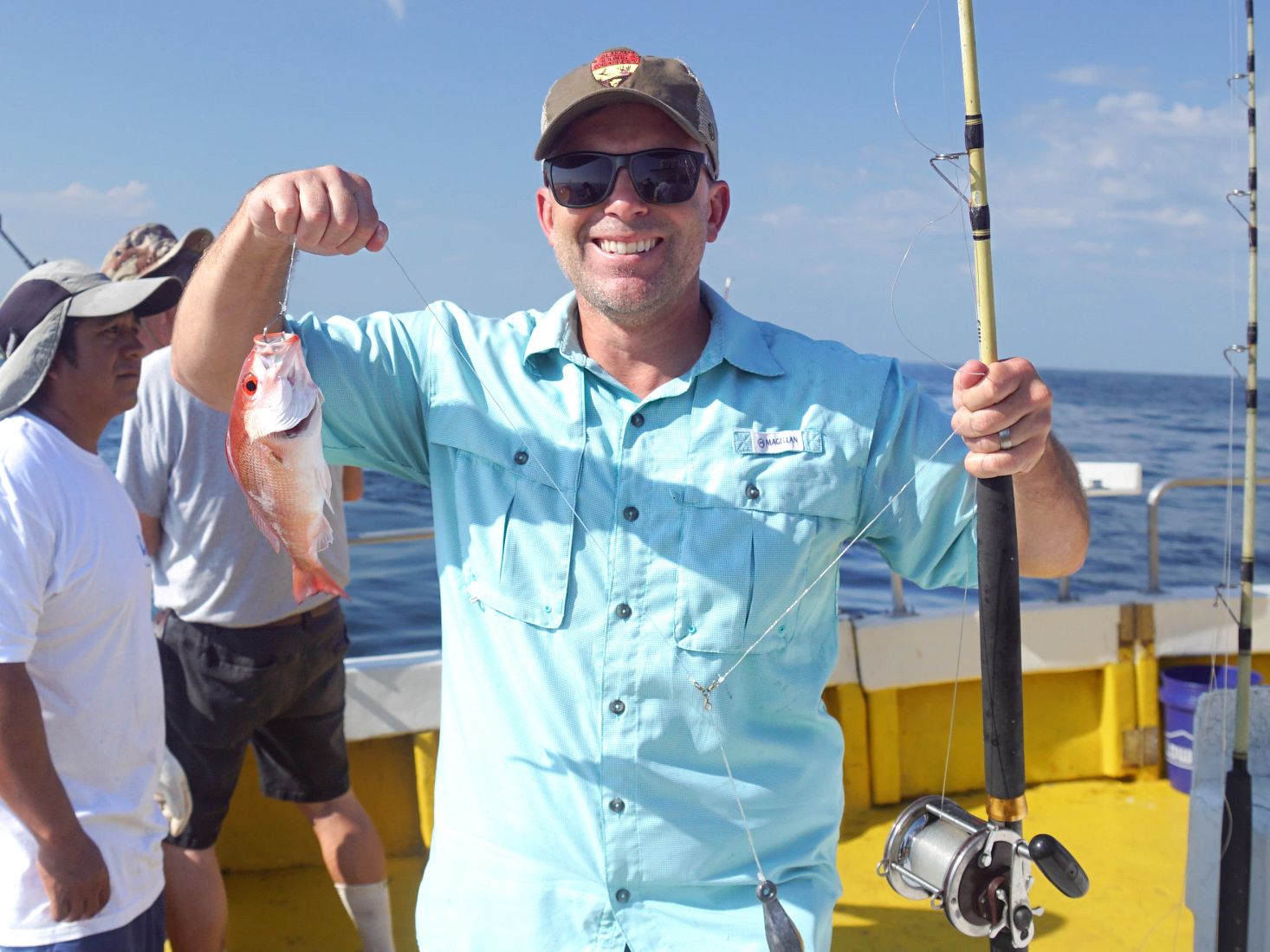 Man holding up a vermillion snapper caught on a fishing charter in Orange Beach