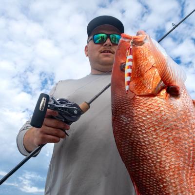 angler holding a large red snapper caught on a charter boat in Gulf Shores