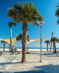 Friends riding bikes along the beach at Gulf Place in Gulf Shores
