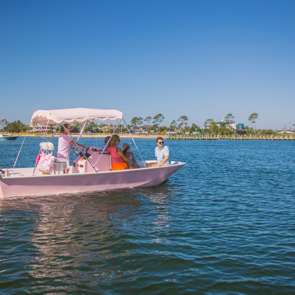 Friends boating on Alabama's Beaches in a pink boat