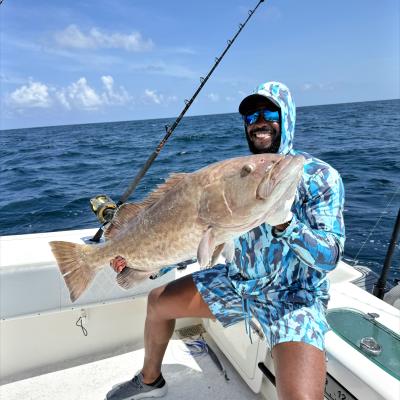 Man proudly holding his grouper catch on Alabama's Beaches