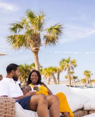 couple dining on the couches at The Gulf beachfront restaurant in Orange Beach