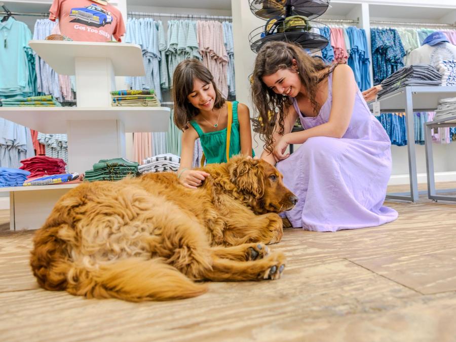 Girls petting a dog in Shades Sunglasses & Apparel at The Wharf